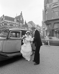 880985 Afbeelding van het bruidspaar Bouman-Zwart, bij een klassieke automobiel voor het Stadhuis (Stadhuisbrug 1) te ...